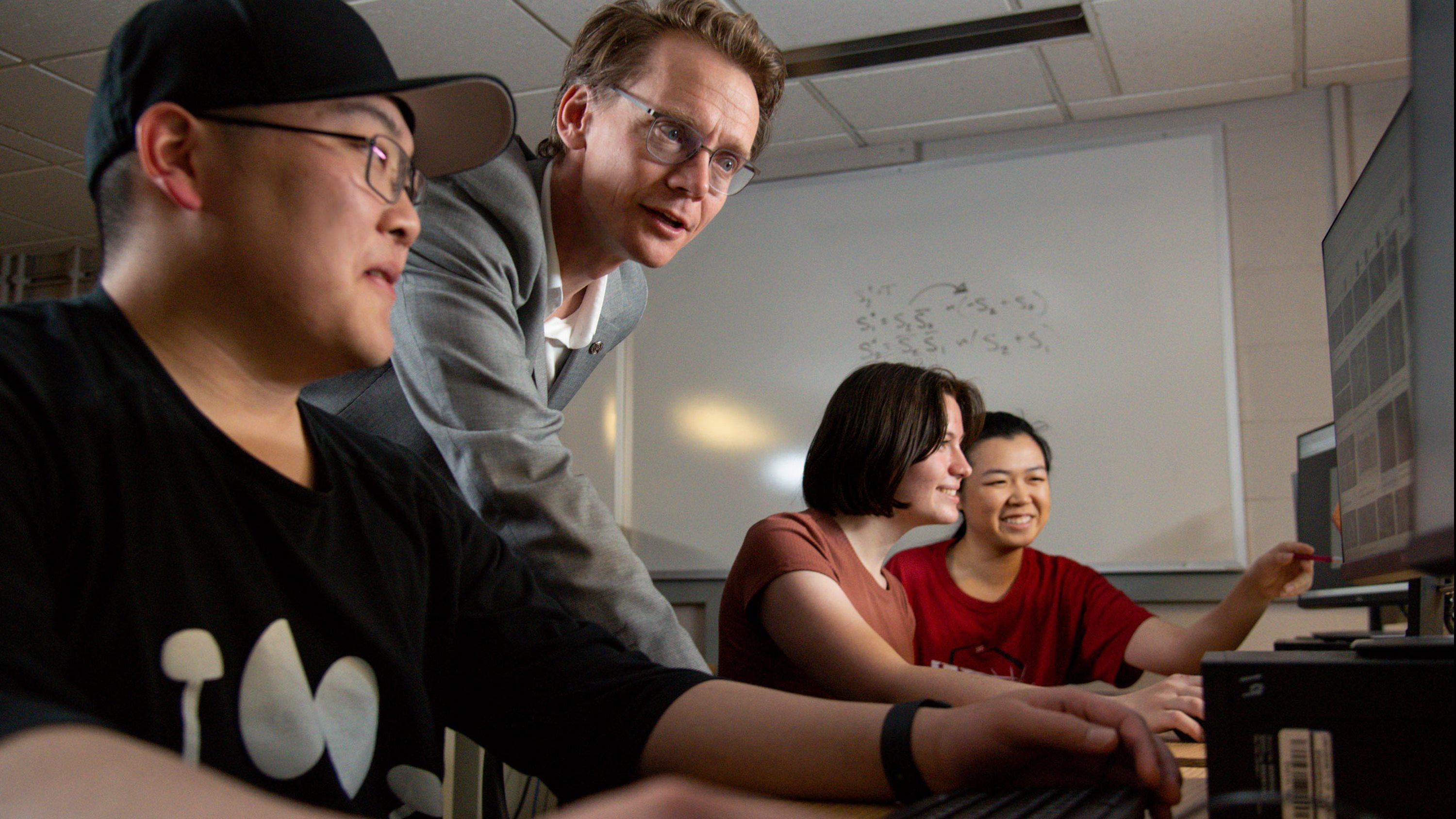 Andr&eacute; Schleife works with students in a lab