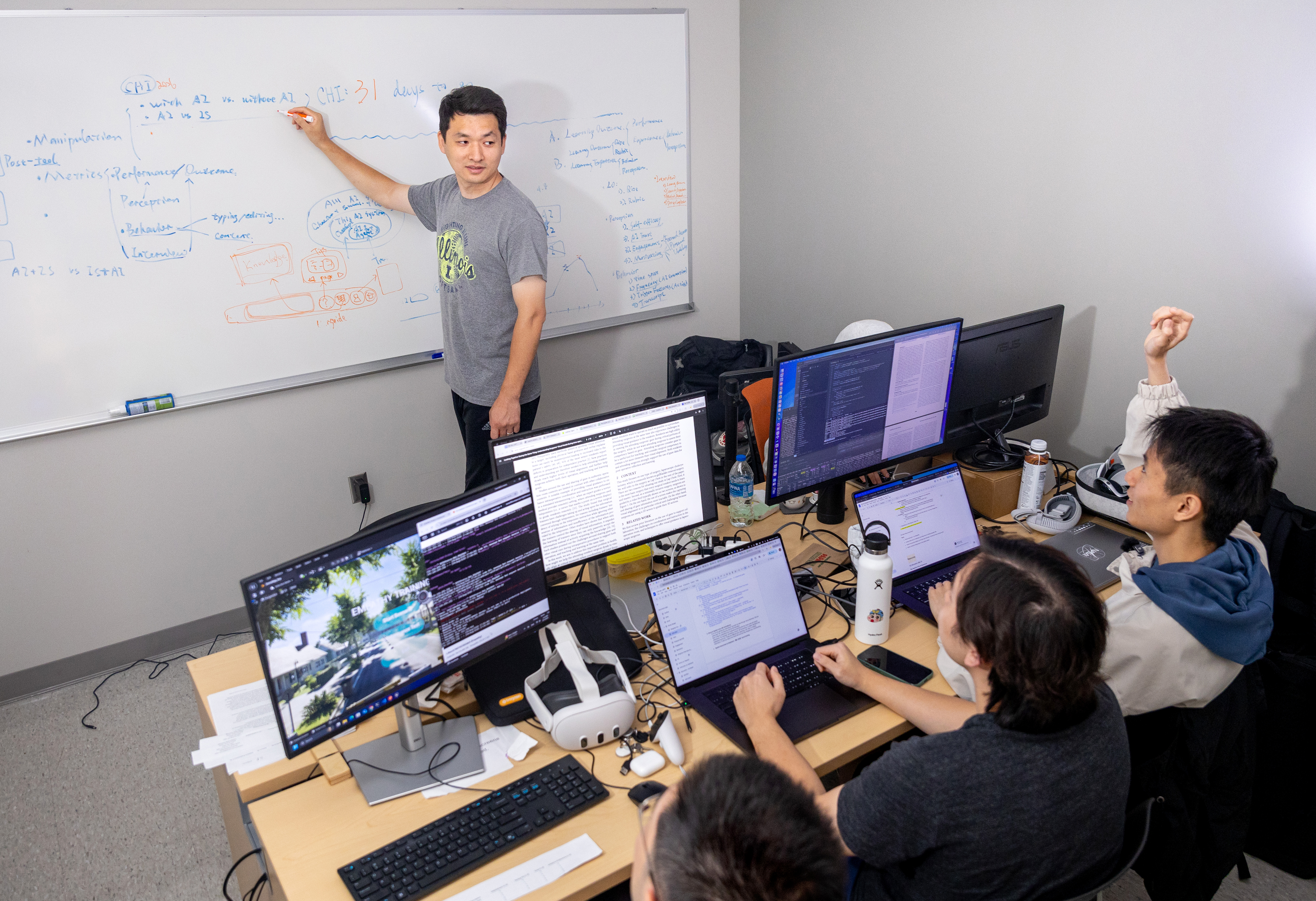 Duo Wang (graduate student) uses the white board to communicate with bottom L-R, Tian Sun, Jackson Song and Kyrian Liang in their empathyin engineering control center at the JUMP Simulation Center at Everitt Lab on Aug. 4, 2025.
