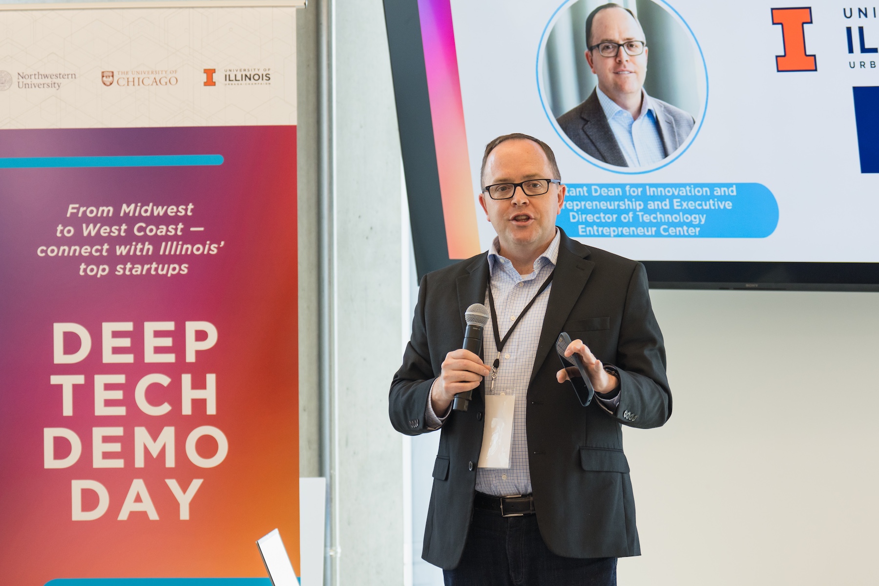 Jed Taylor holding a microphone and delivering a presentation