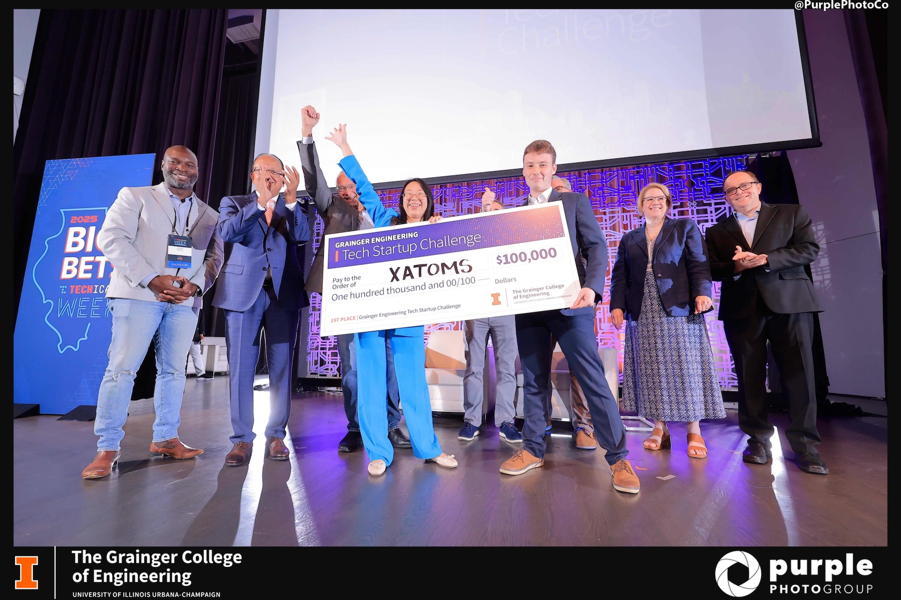 Photo of students holding over-sized check for $100,000 dollars.