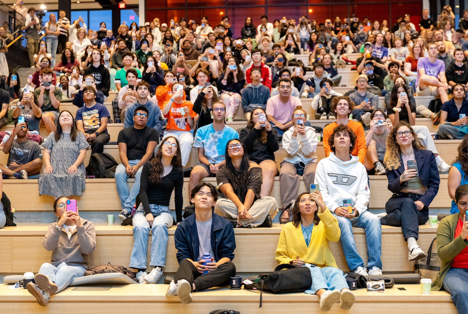 A large group of students and community members sit on the Monumental Steps at CIF during a watch party for NASA's Carruthers Geocorona Observatory launch at Cape Canaveral.