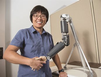 Liz Hsiao-Wecksler shaking hands with a robotic arm