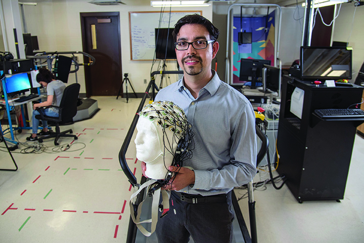 Manuel Hernandez holding mannequin head covered in electrodes