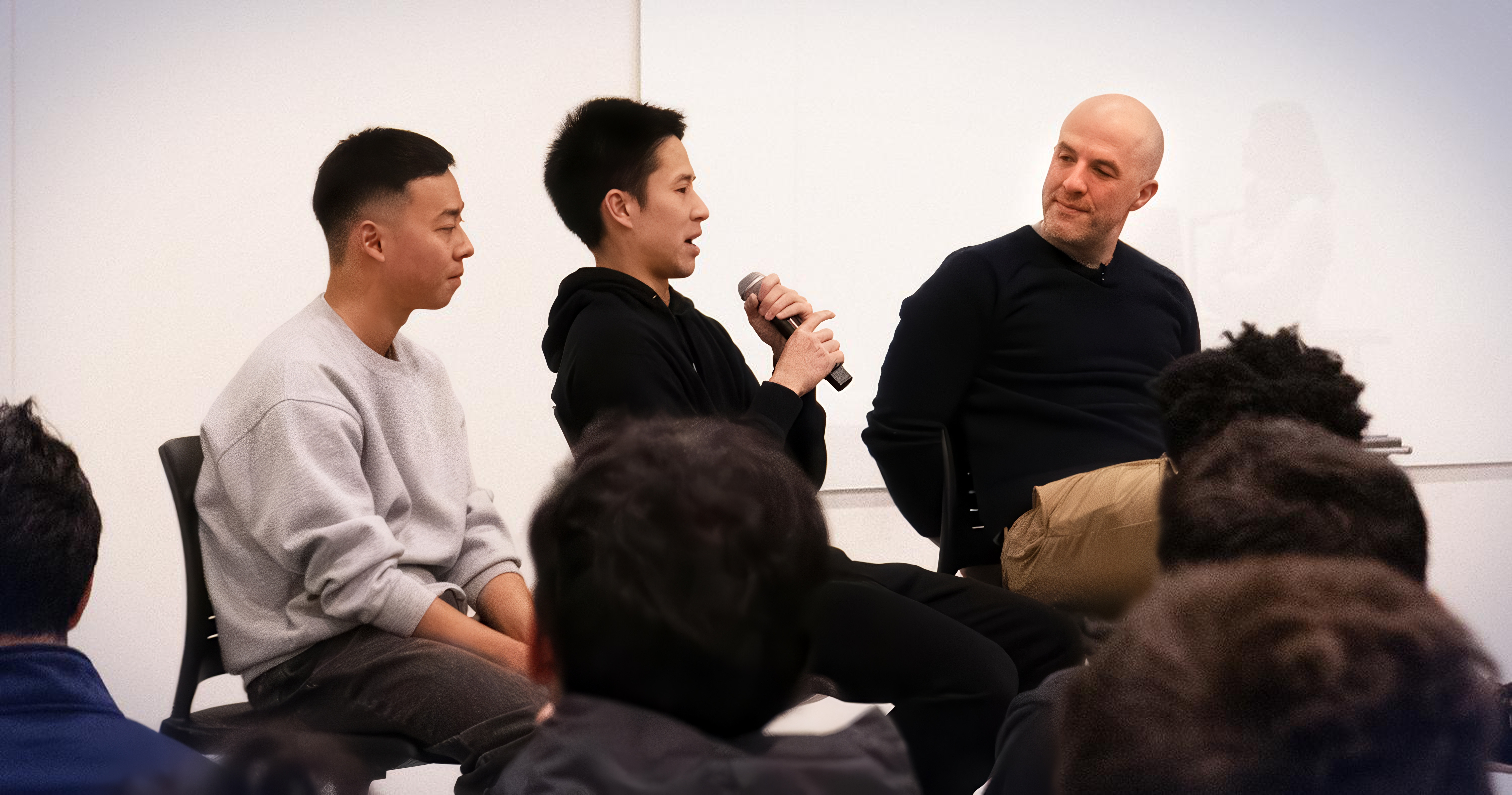 Pete Koomen, Andy Li and Raymond Huang sit on stools on a stage with an audience in the foreground.