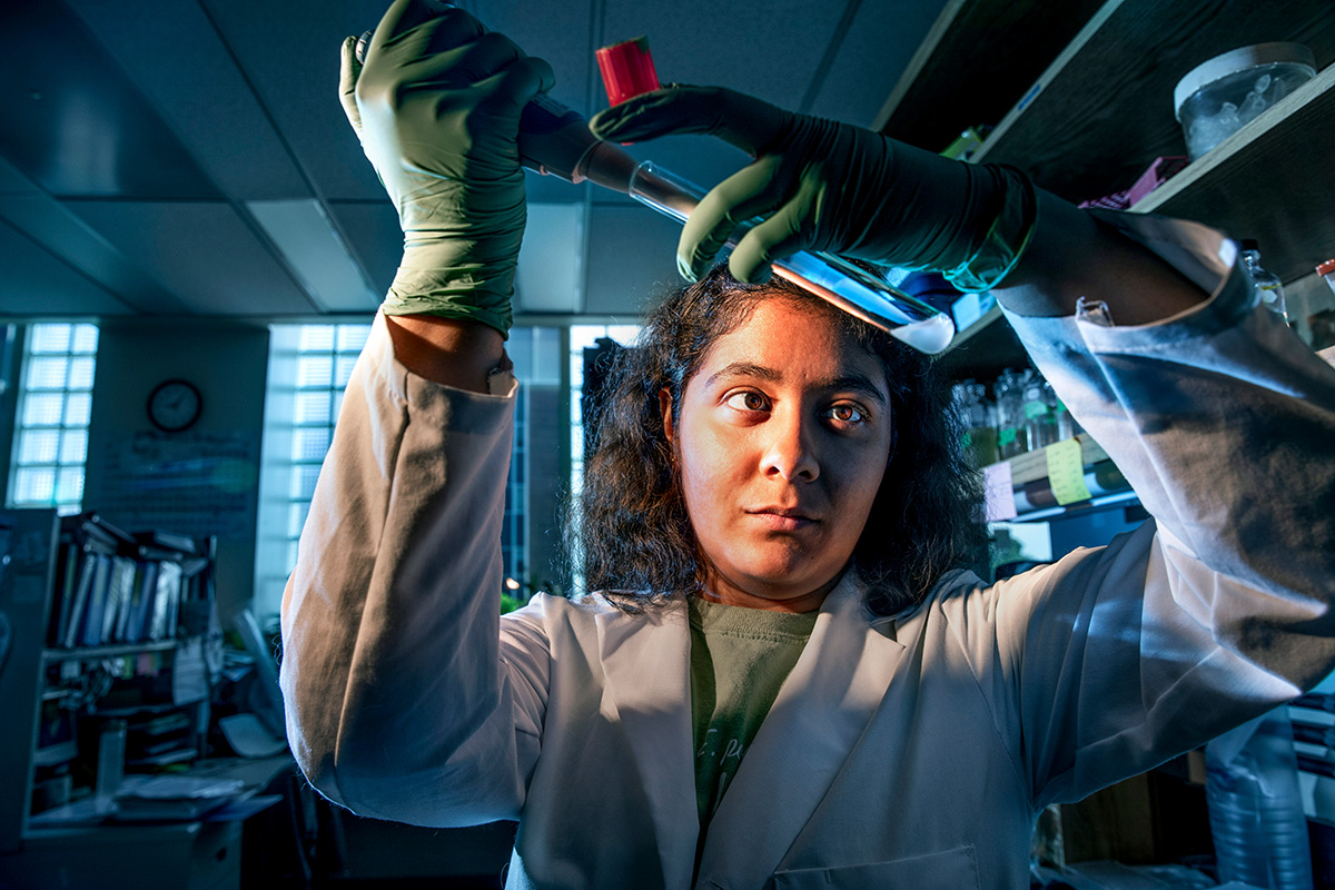 Student in lab extracting liquid from test tube
