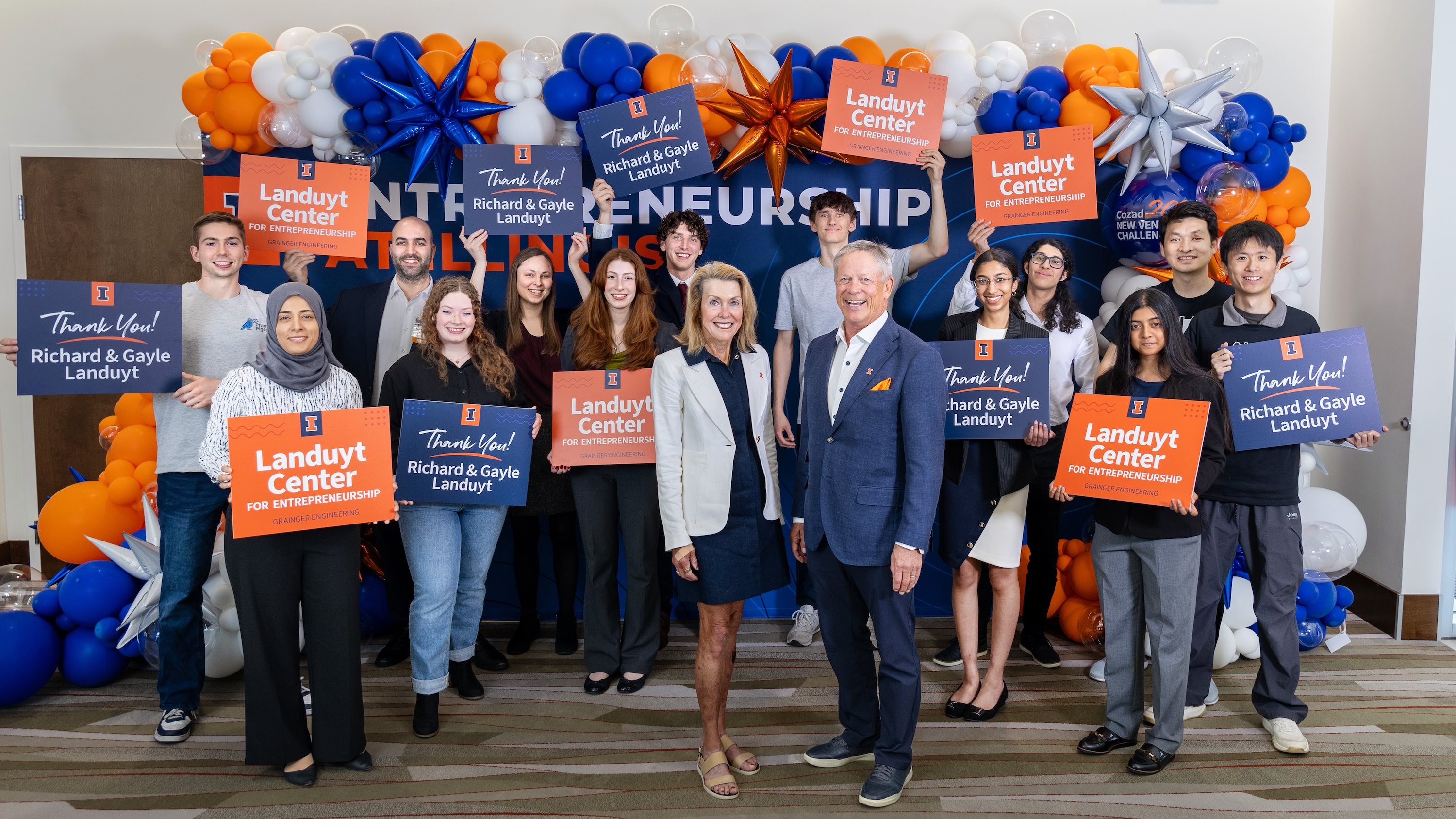 Gayle and Richard Landuyt surrounded current Grainger Engineering students holding signs thanking them for their transformational $20 million commitment to drive entrepreneurial education at Illinois.
