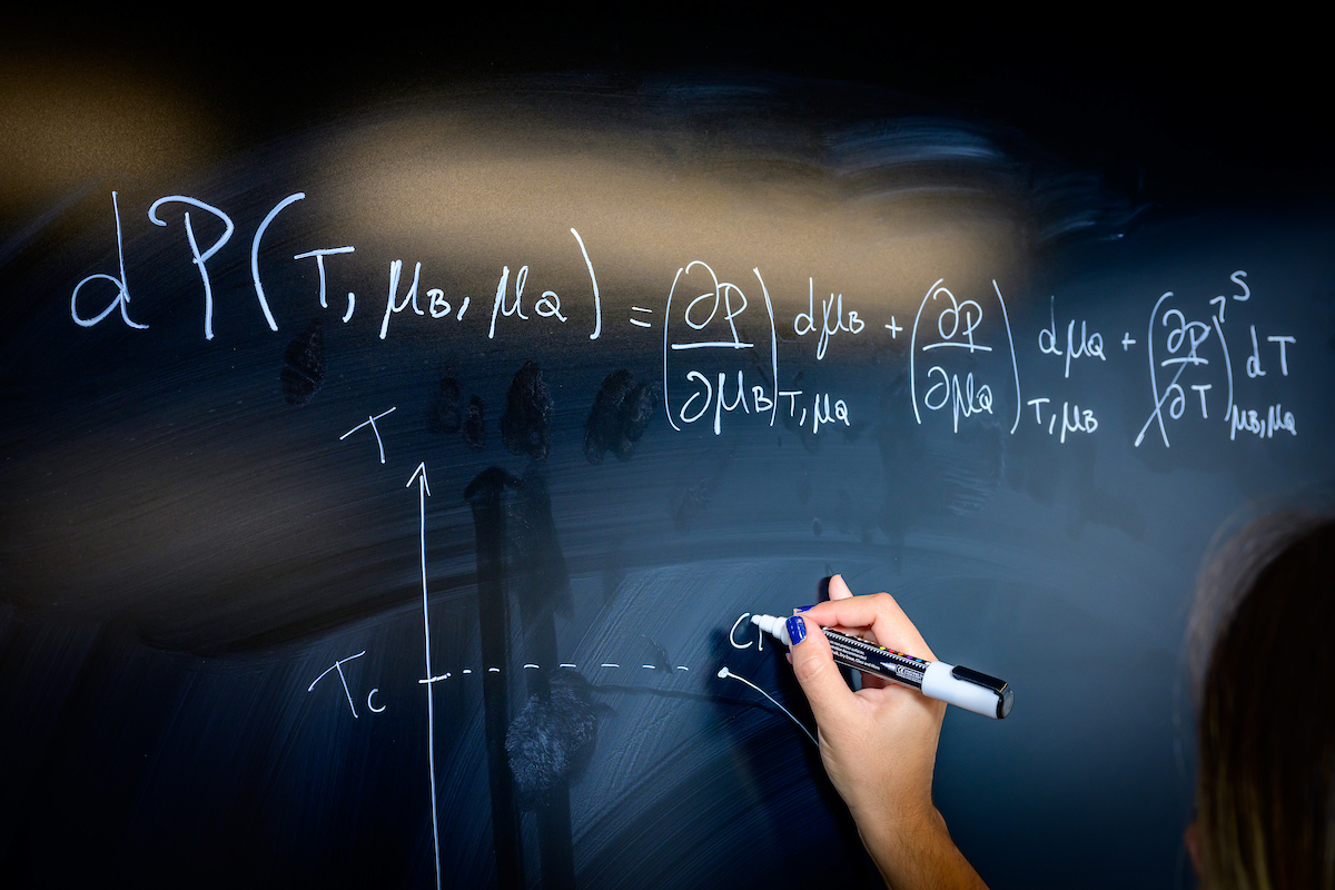 Up-close shot of an individual's hand writing on a board at Loomis Laboratory.