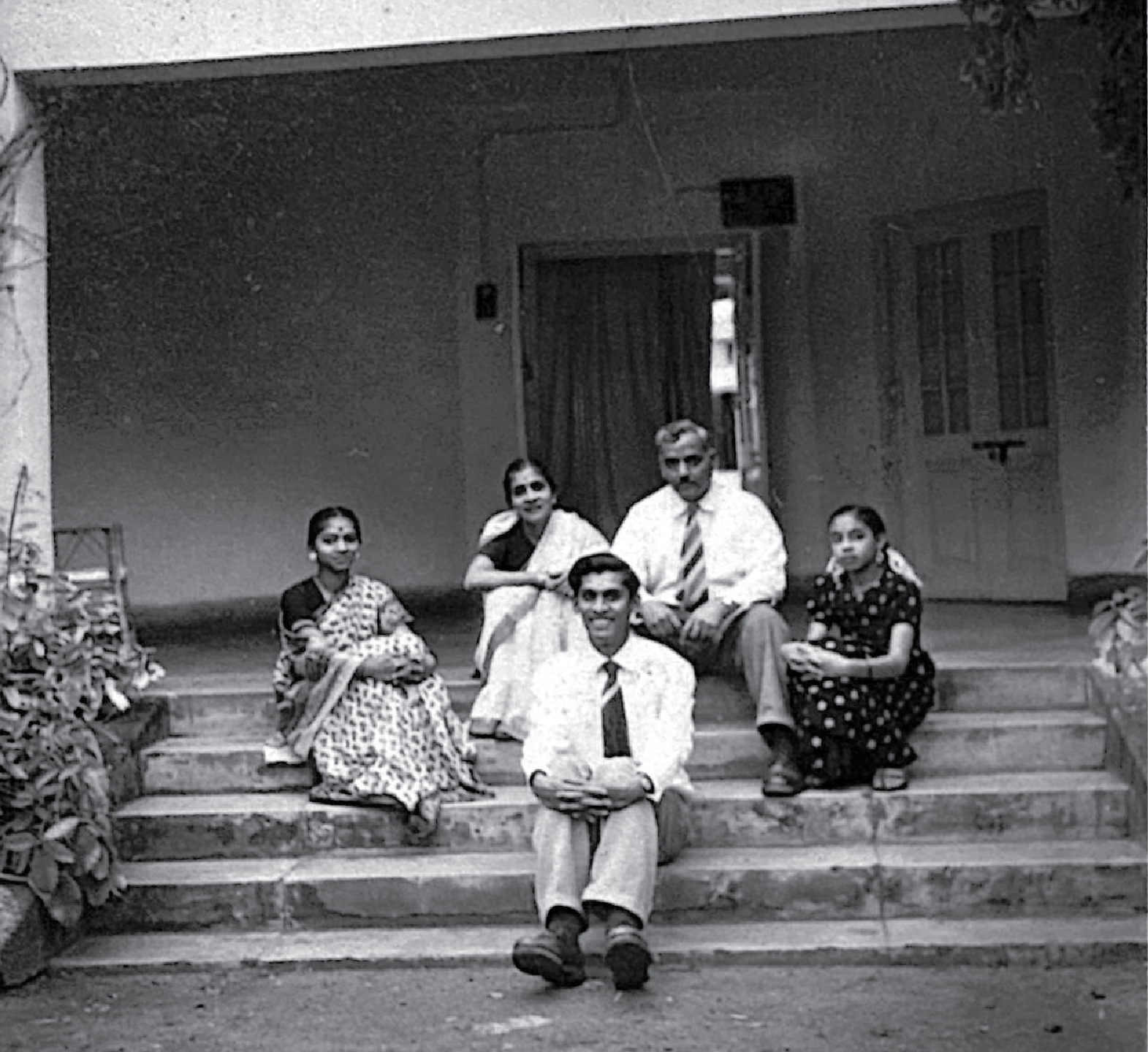 Talwalkar family siting on building steps, 1952.