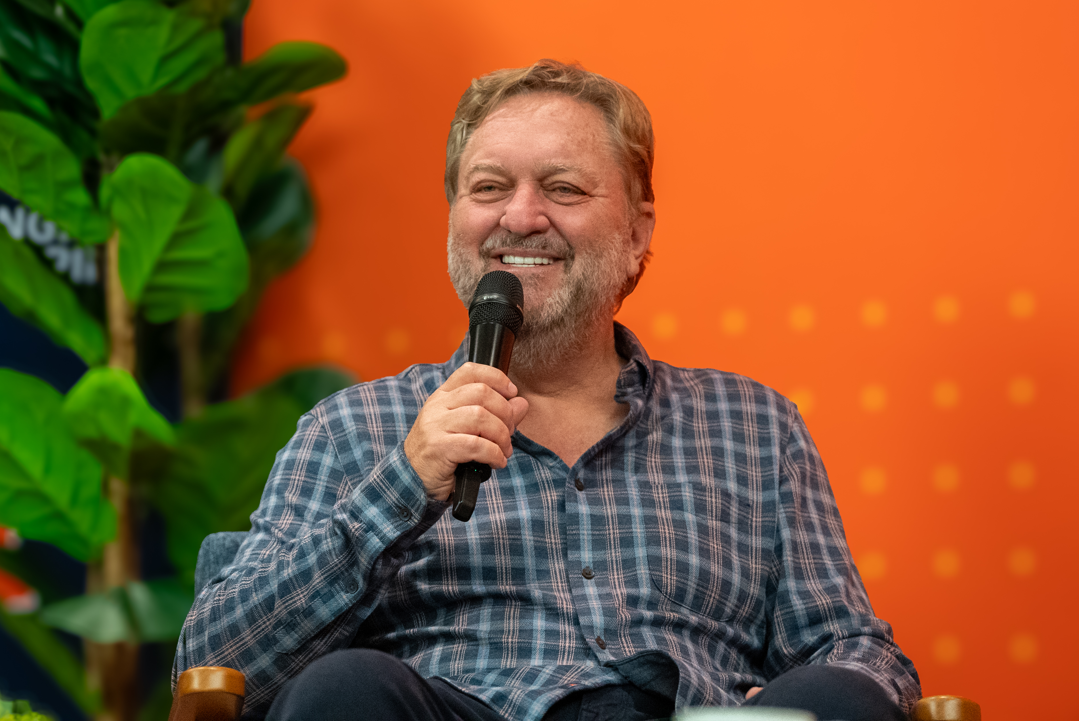 Dan Caruso smiling and holding a microphone.
