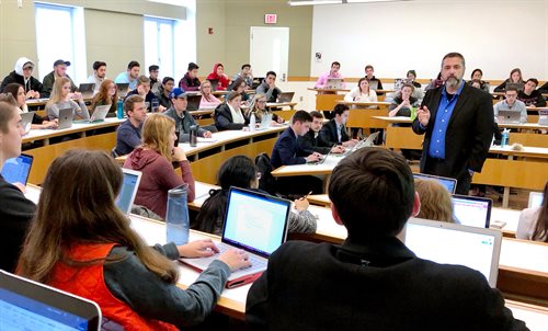 Professor speaking to a lecture hall full of students