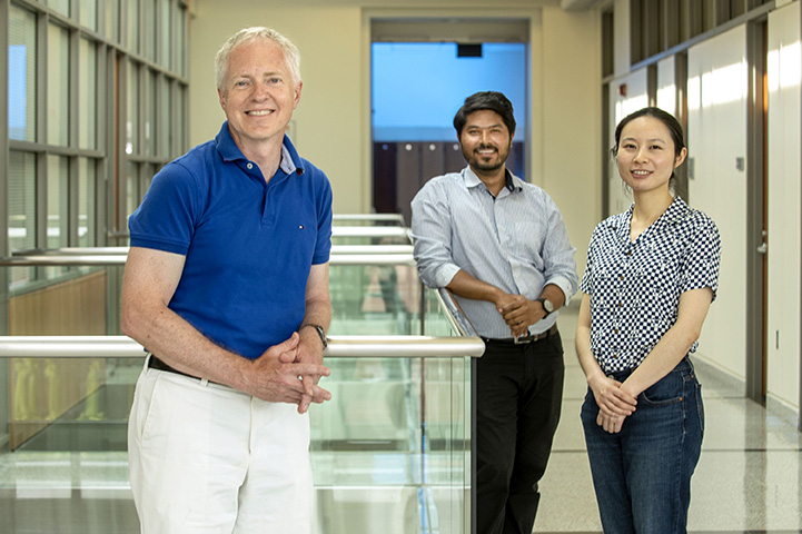 Brian Cunningham, ECE professor, is helping to lead a research team in creating a sensitive smartphone-based testing device for viral and bacterial pathogens that takes about 30 minutes to complete. The smartphone accessory could help test for COVID-19. Cunningham is pictured at Holonyak MNTL on June 8, 2020. Fu Sun, far right, Graduate Research Assistant, and Anurup Ganguli, Research Scientist, seen here, are part of the research group.