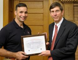 Lee Archambault receives his Distinguished Alumni certificate from Mike Bragg, Executive Associate Dean for Academic Affairs.