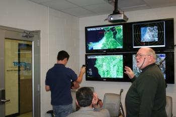 Professor Ed Herricks explains the displays of live radar images from Seattle-Tacoma Airport and the Naval Air Station at Whidbey Island, airports at which he is conducting wildlife safety research.