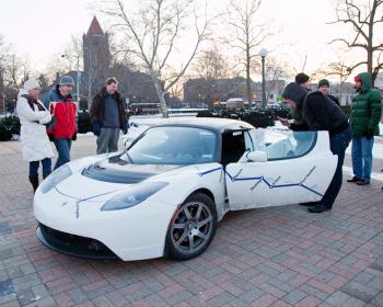 Electric vehicle enthusiasts and engineering students check out a Tesla Roadster that stopped by the engineering campus for a public viewing and to recharge its batteries.