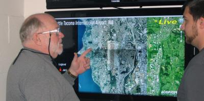 Professor Herricks explains live image of Seattle-Tacoma International Airport avian radar information to staff in the CEAT office.