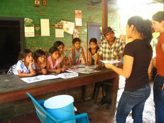 Ofelia Romero and Kim Parker teaching a family about the biosand filter and proper hygiene.