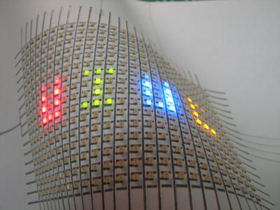 A flexible array of LEDs mounted on paper. Hand-drawn silver ink lines form the interconnects between the LEDs. 