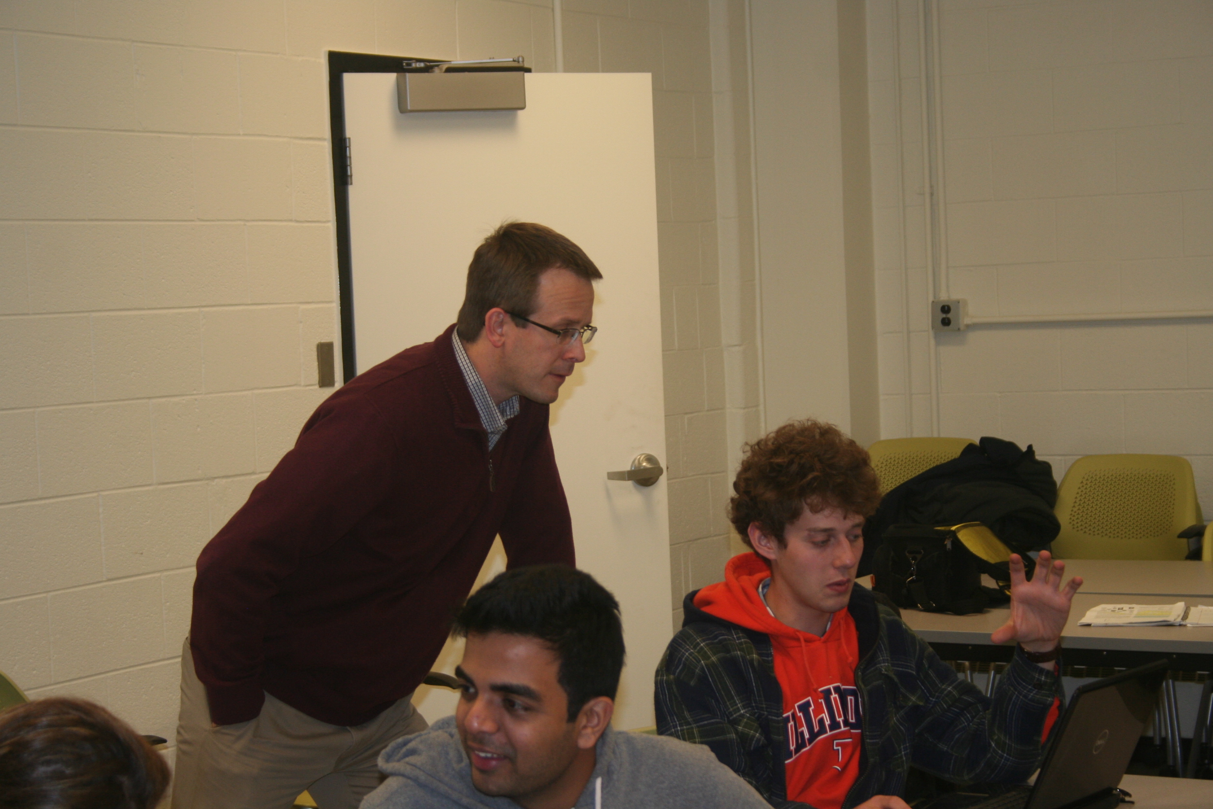 Professor Jeff Roesler helps students with their group project on sustainability.