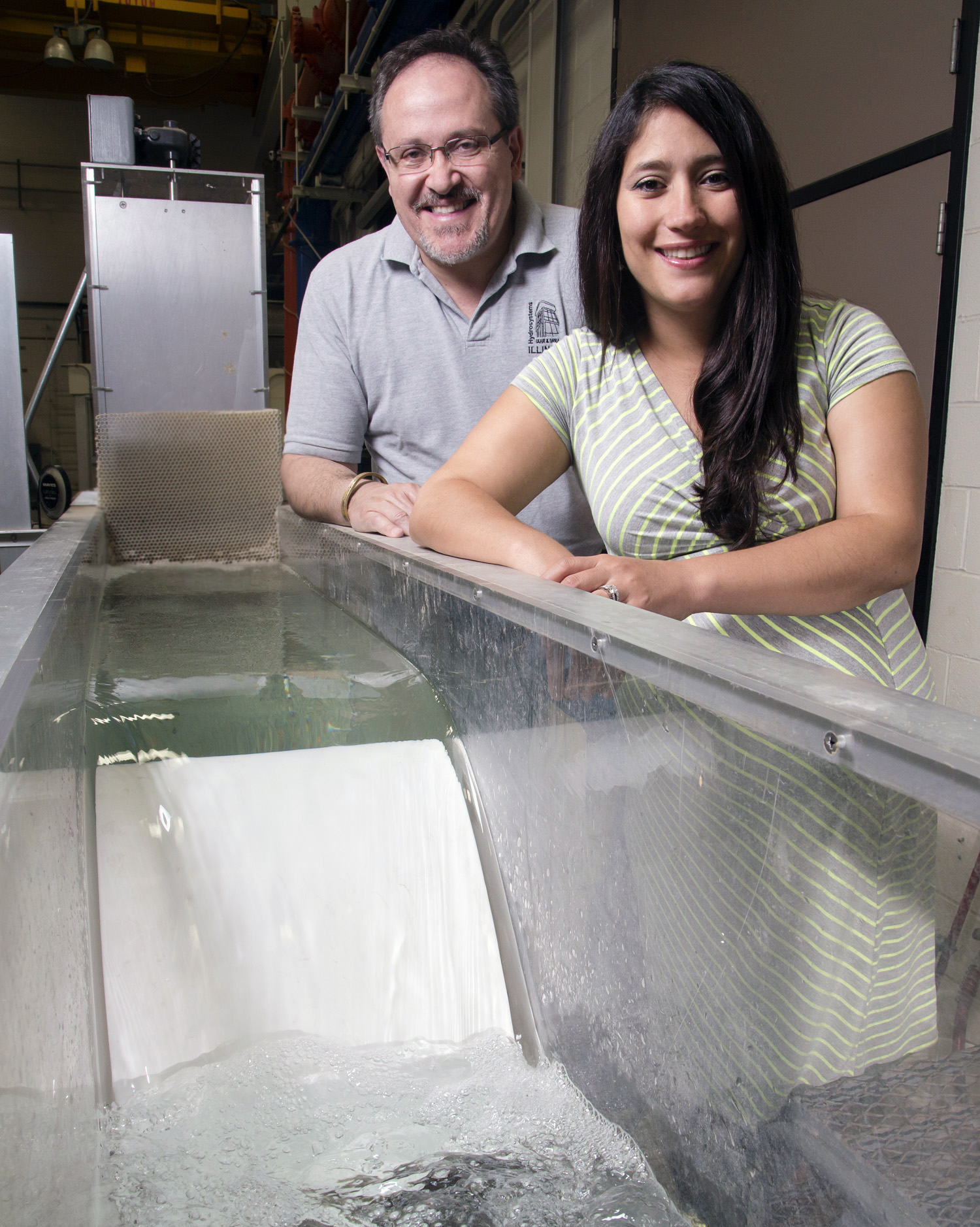 CEE professor Marcelo Garcia and USGS research hydrologist Tatiana Garcia with a physical model of a low head dam in the Ven T. Chow Hydrosystems Laboratory that represents Asian carp spawning location.