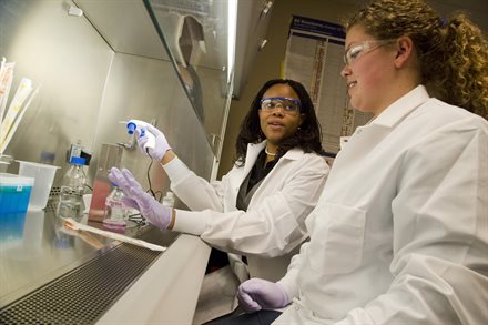 BioE assistant professor Princess Imoukhuede offers a 'hands-on' demonstration to a student in her lab.