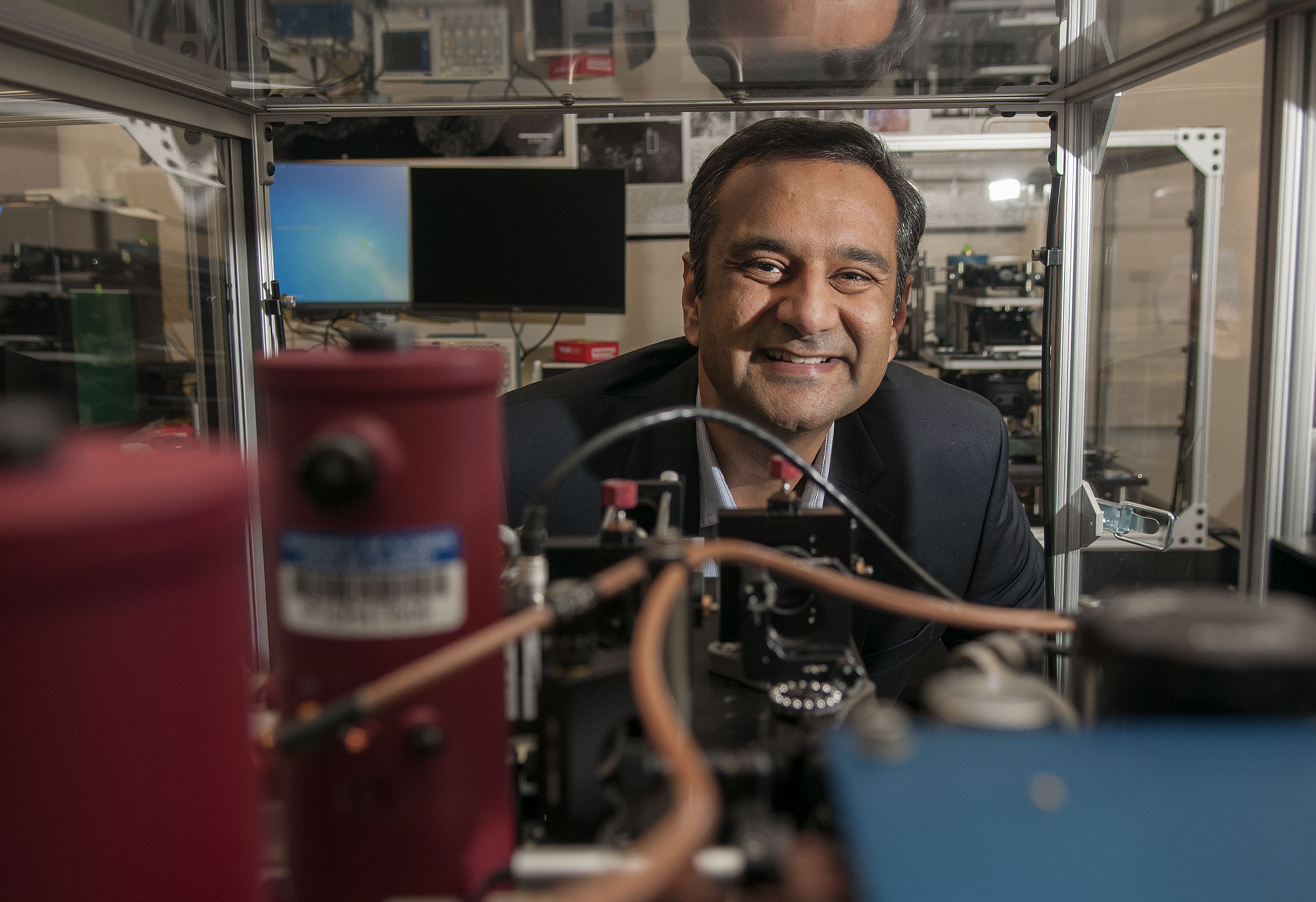 Rohit Bhargava peers through equipment in a lab.