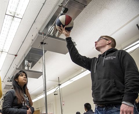 Students drop a basketball in a physics lab experiment
