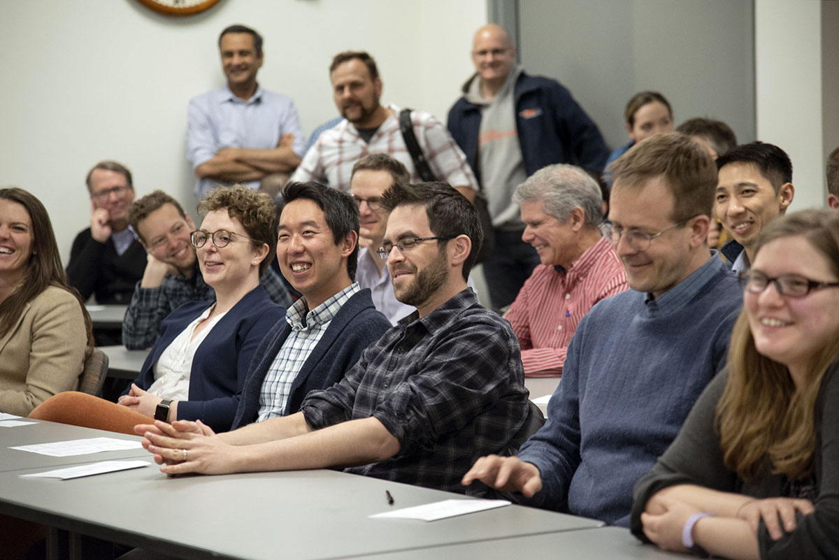 Faculty sitting at a table smiling