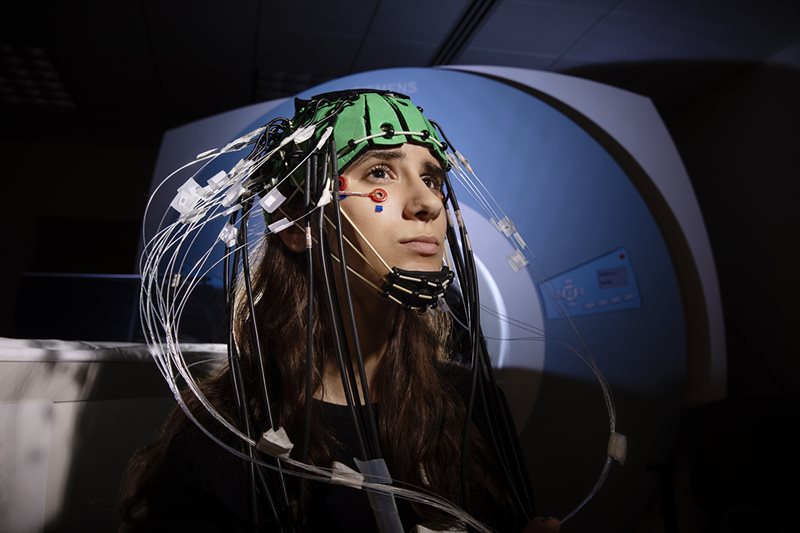Student models an EROS helmet with EEG drop electrodes