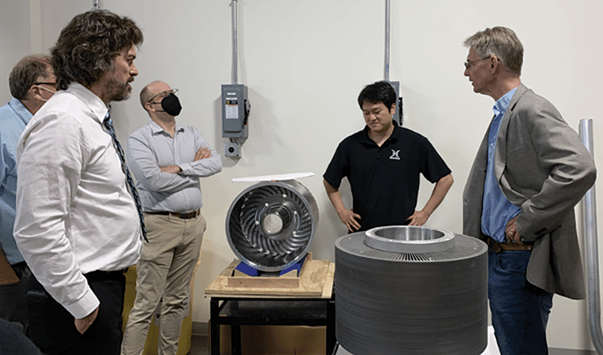 group of men standing in group looking at lab equipment