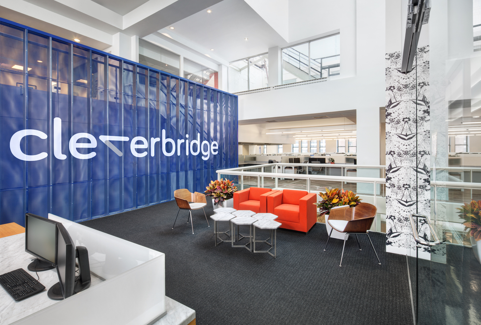 rendering of cleverbridge office with computers, chairs, and wall with logo