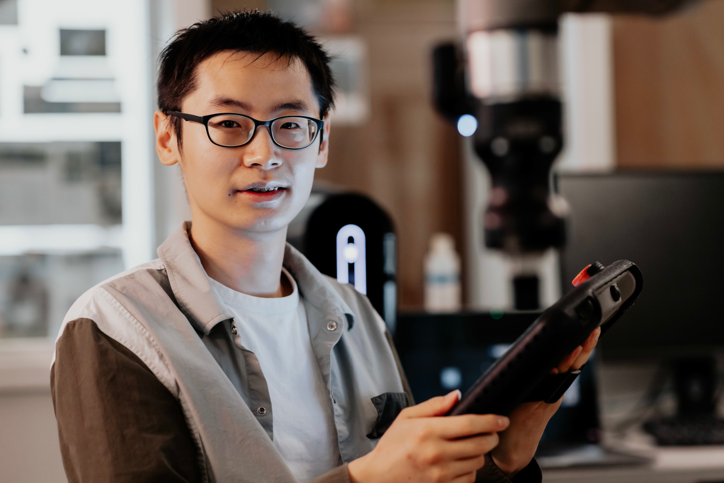 student holding ipad in engineering lab