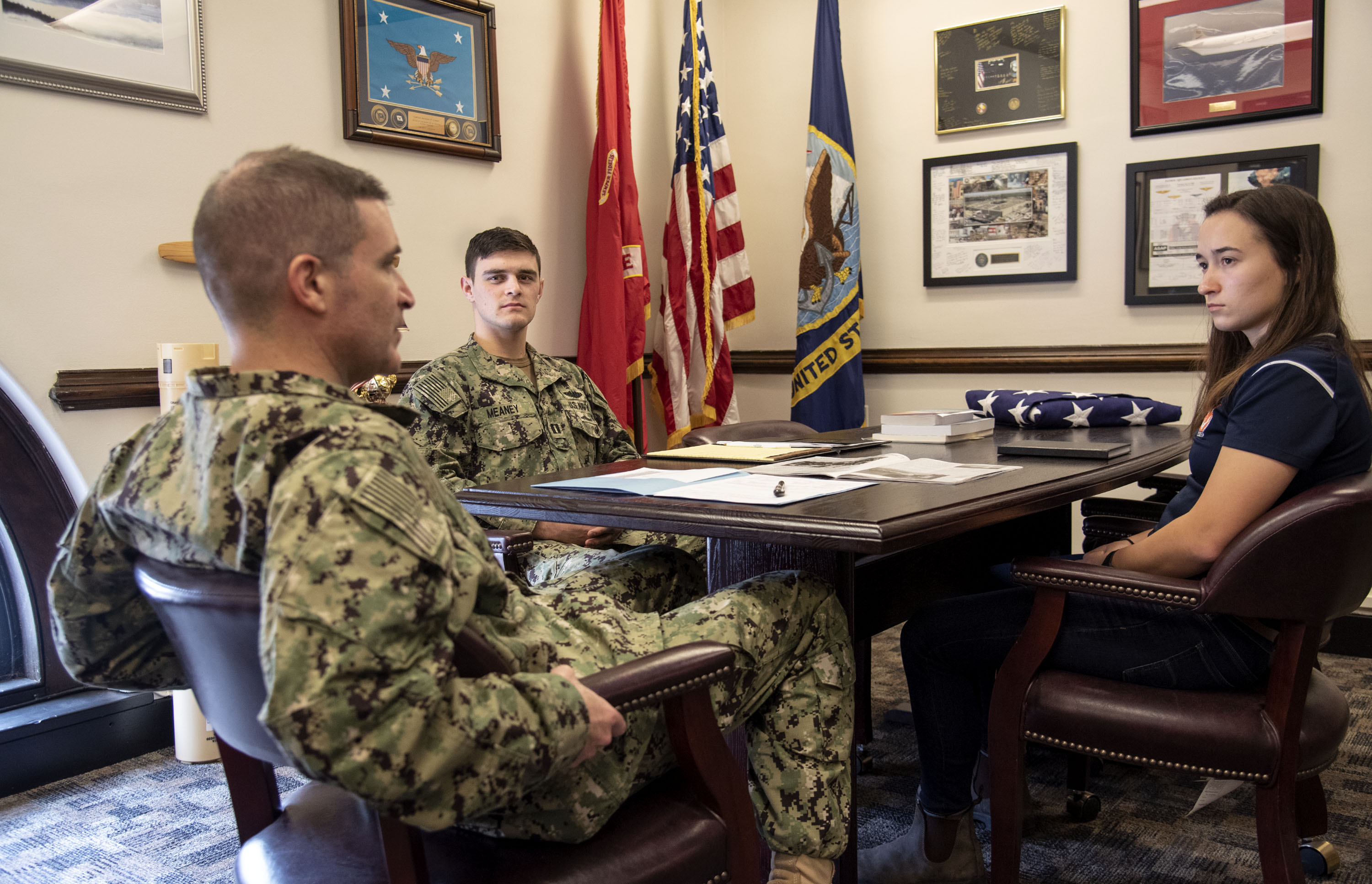 Lt. Daniel Meaney, USN, center, and Capt. Anthony Corapi, CO, &nbsp;University of Illinois NROTC, left, review a midshipman's fitness evaluation at the Navy ROTC offices at the UI Armory during early spring semester. Lt. Meaney's military family includes his father, Michael Meaney, chemical engineer and defense contractor; his grandfather, Thomas Meaney, radar engineer and defense contractor; an uncle, Robert Meaney, U.S. Marine Corps., platoon commander; to name a few. <em>Photo by Heather Coit</em>