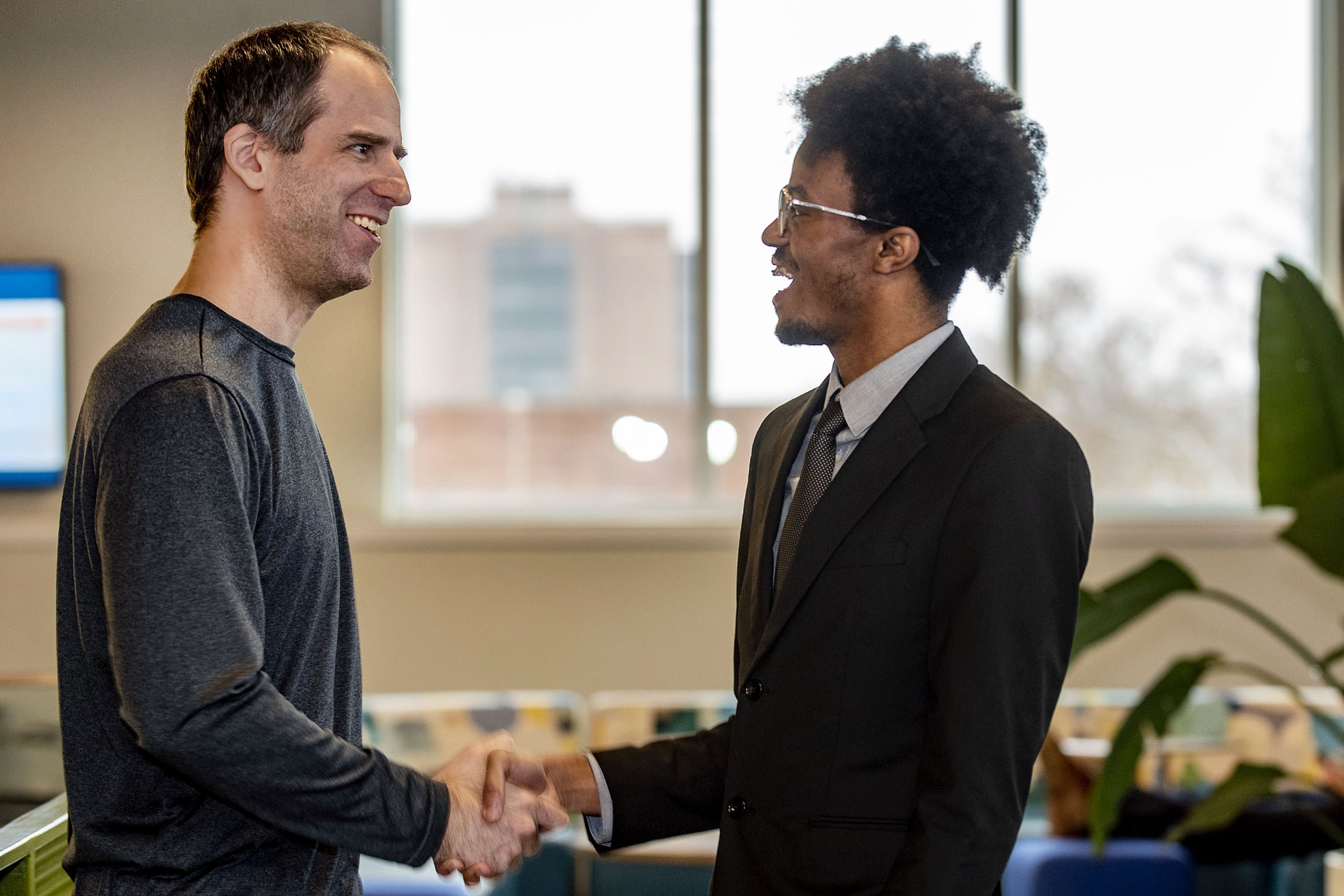 Members of the enhanced pent design team shake hands