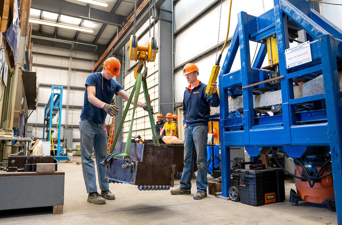 RailTEC's Marcus Dersch, 
principal research engineer, right, looks on as Coleman Froehlke, graduate research assistant, gets hands-on training at the Research and Innovation Laboratory (RAIL) in Champaign in April 2024.