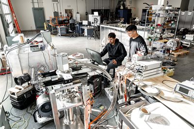 Two male engineers performing research on a superconducting machine at the Power Optimization of Electro-Thermal Systems (POETS) Research and Development Center in Champaign, Illinois.