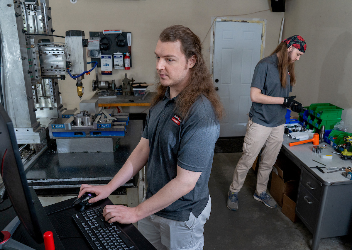 Twin brothers Robert, right, and Richard Mauge show off the CNC machine they built in their garage in Champaign on April 29, 2024. The brothers own Matrics Design and Engineering, which  manufactures technical and artistic products catered to smaller businesses, start-ups, student groups and research groups.