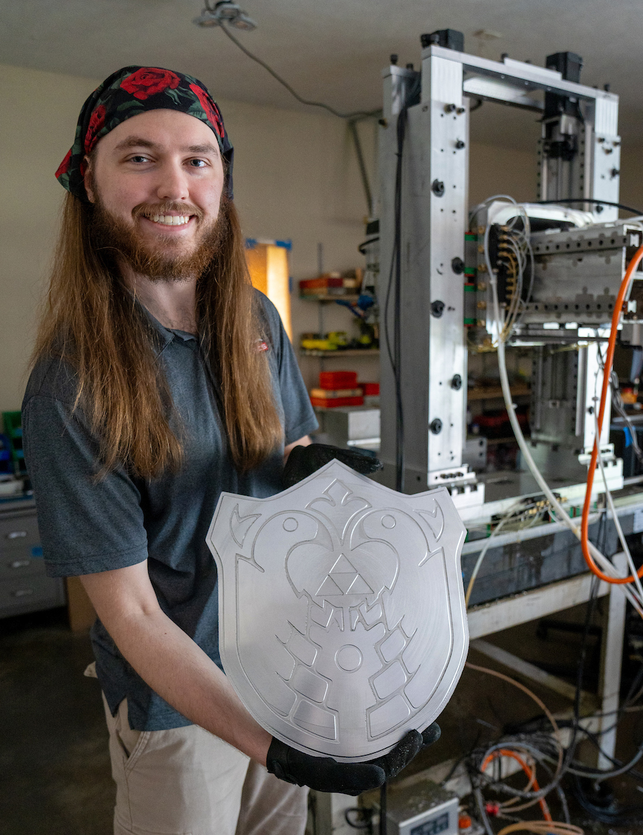 Robert Mauge shows off the aluminum shield he made, in the style of The Legend of Zelda: The Wind Waker video game.