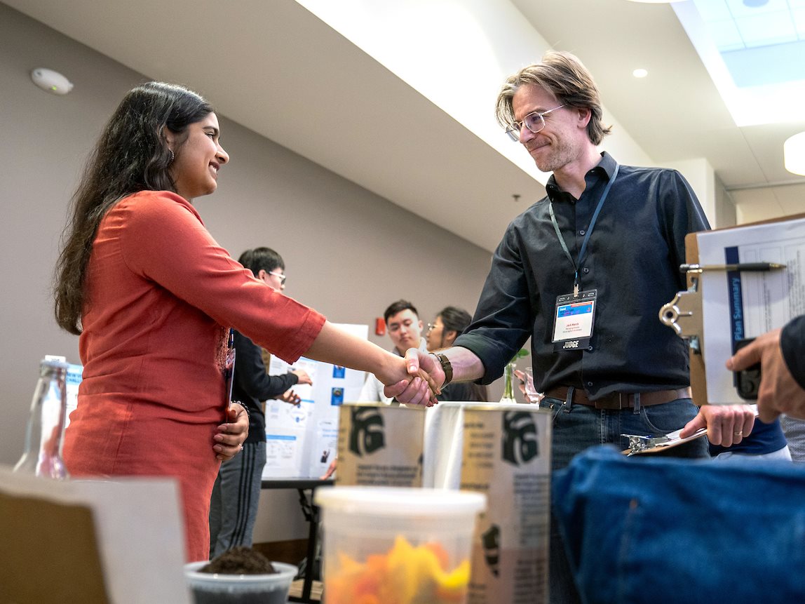 Jeevatva's Sakshi Vaya, left, greets judge, Jack Marck (Managing Director of the Illinois AgTech Accelerator).Student entrepreneurs pitch their start-up to judges during the Cozad New Venture Challenge's Demo Day at the I Hotel and Conference Center in Champaign on Thursday, April 11, 2024.
