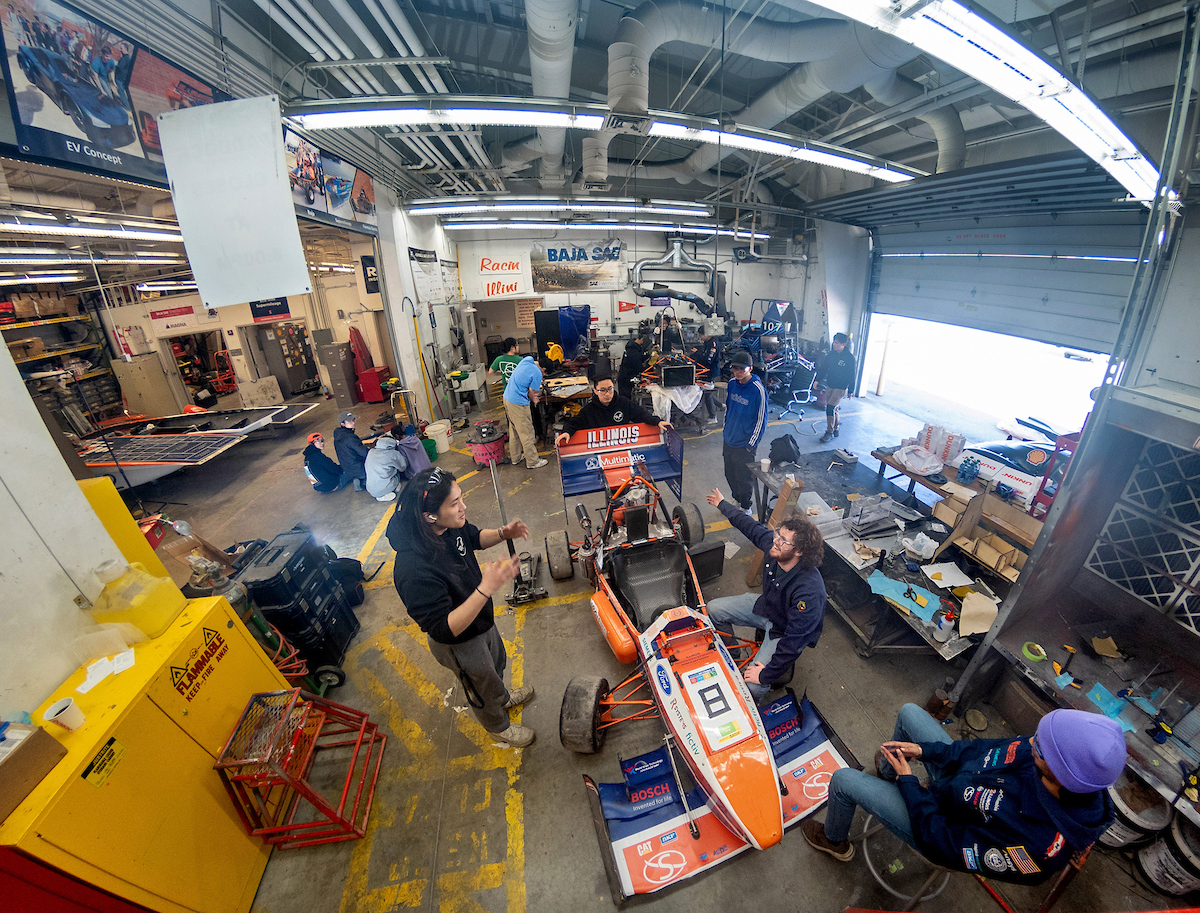 Overhead view of students working on a car in the Engineering Student Project Laboratory.