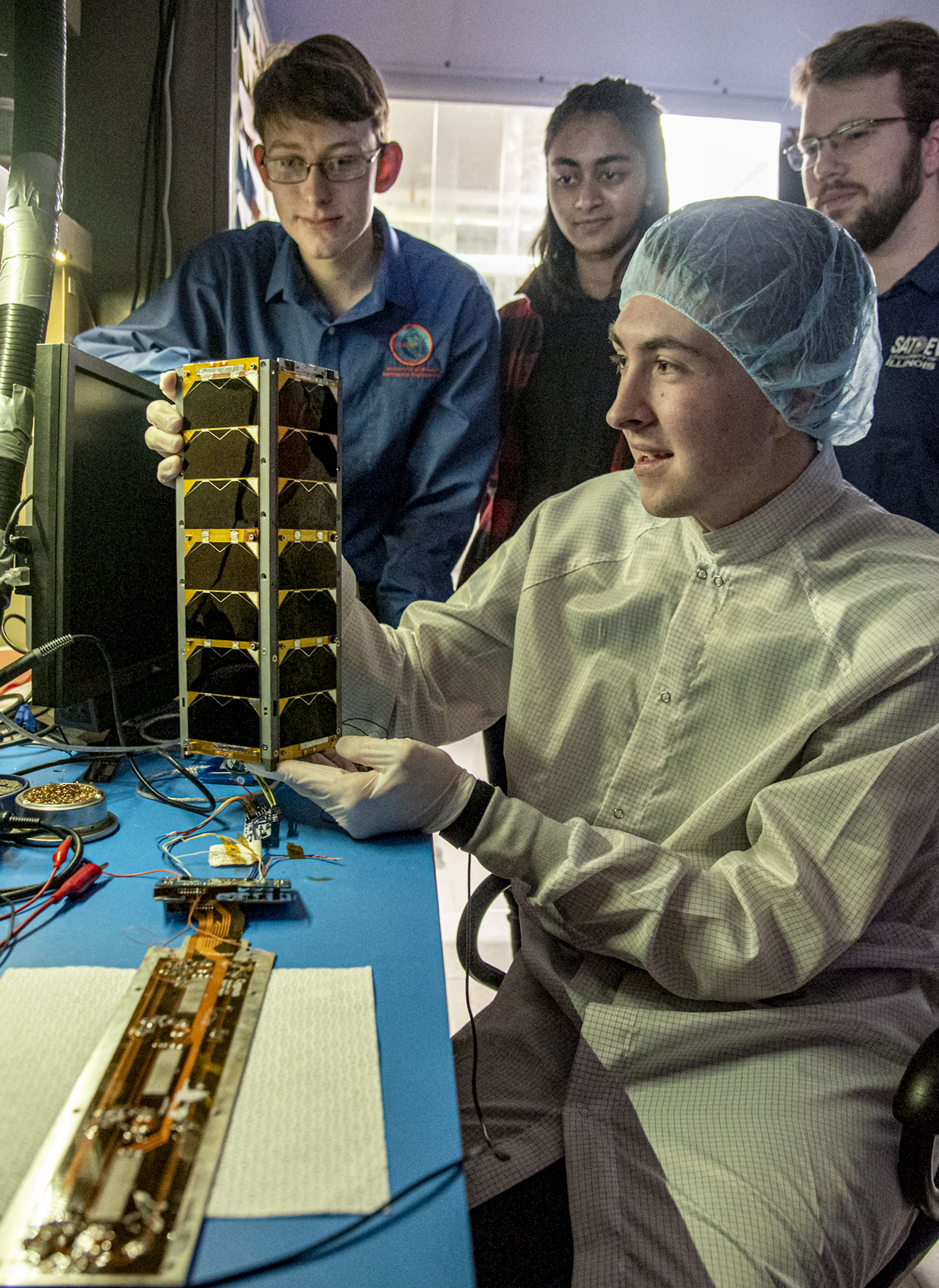 Members of The Satellite Development Organization, or SatDev, work with a CubeSat in the Laboratory for Advanced Space Systems (LASSI) at Illinois.