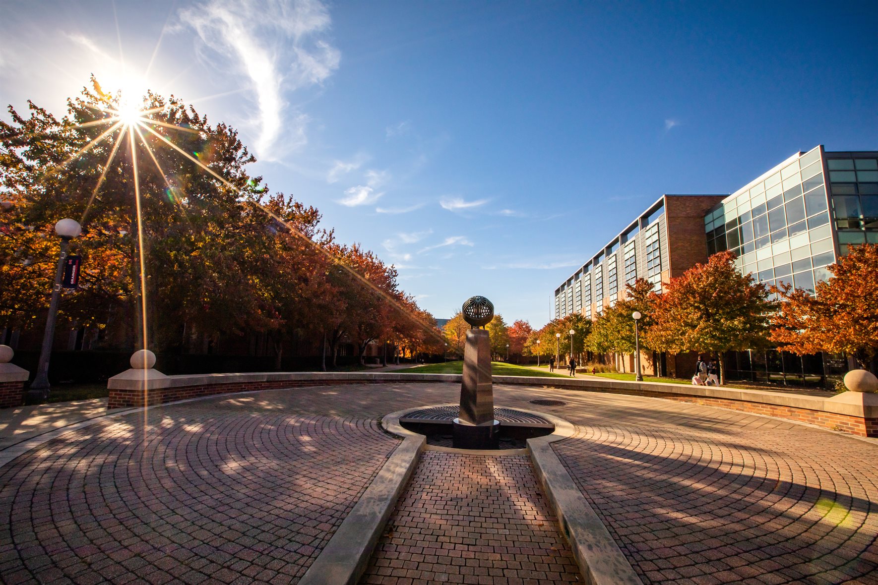 The Upwells statue looks elegant on the Engineering campus during the autumn season as the sun shines through the trees.