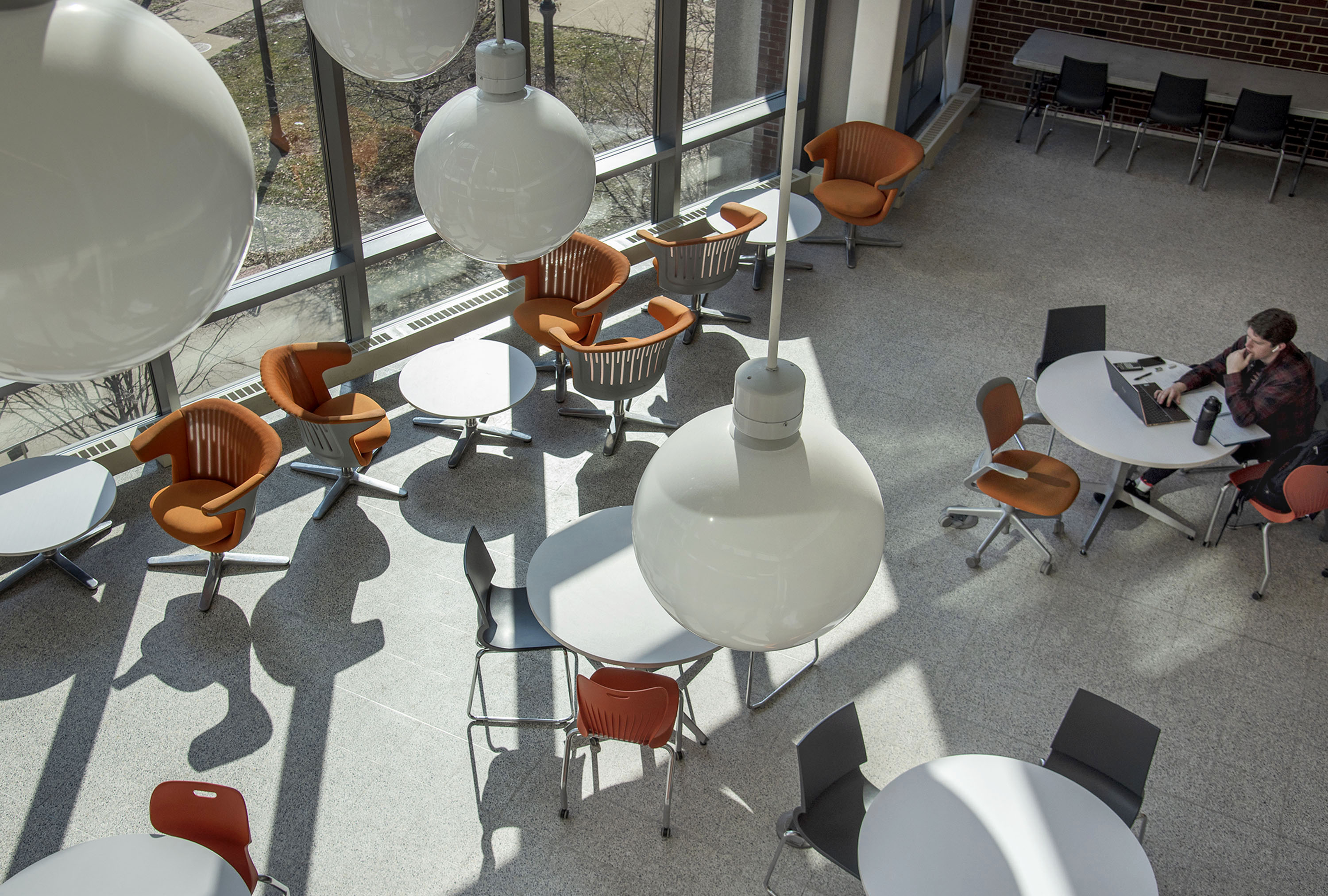 The sun's rays stream through the large windows of Geoffrey Yeh Student Center at Newmark Hall as students review classroom work in bright surroundings in Urbana on Wednesday, Feb. 19, 2020.