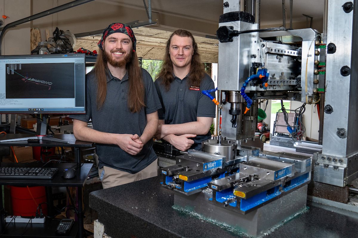 Twin brothers Robert, left, and Richard Mauge show off the CNC machine they built in their garage in Champaign.